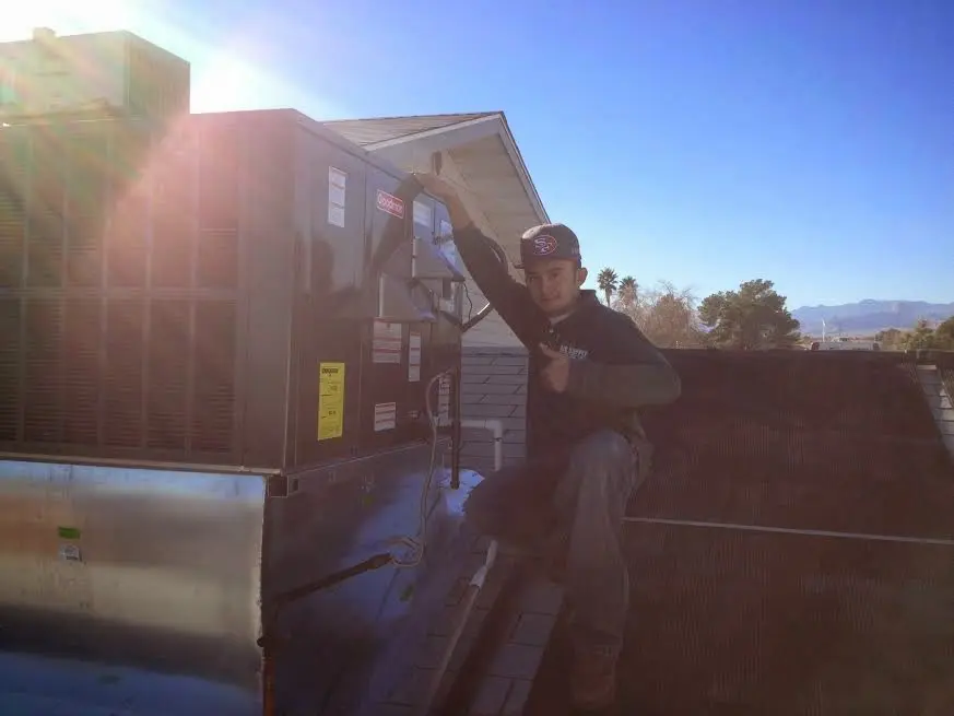 HVAC technician performing AC Tune-Up on a rooftop unit in Kapolei
